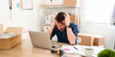 Homme stressé devant son ordinateur à cause du planning du personnel dans un bureau d’entreprise