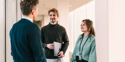 3 collega's die met elkaar aan het praten zijn