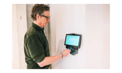 Werknemer klokt in met een badge op een wandklokterminal KLOKSYSTEEM