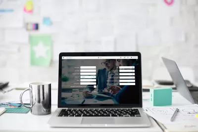 Laptop op een bureau met een bezoekersregistratiescherm