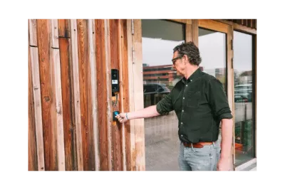 Werknemer die een badge gebruikt om toegang te krijgen tot een gebouw via een terminal voor toegangscontrole